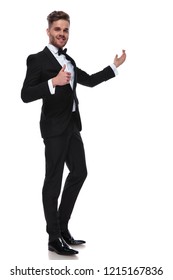 Happy Elegant Man In Tuxedo Presenting And Making The Ok Thumbs Up Hand Sign On White Background