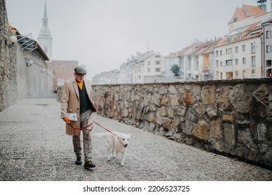 Happy Elegant Senior Man Walking His Dog Outdoors In City.