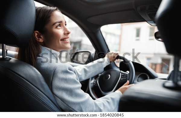 Happy elegant\
woman driver looking at person sitting in her car, pick up\
passenger. Businesswoman drop friend to meeting. Female executive\
talking to someone through car\
window.