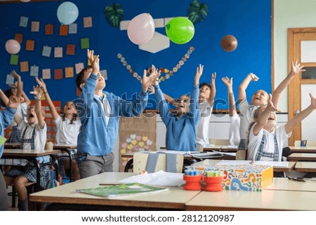 Happy elementary school students playing with balloons during an interactive classroom activity