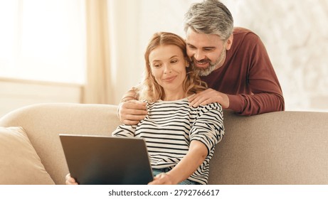 Happy Embracing While Using Laptop At Home, Warm Cozy Setting