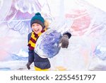 happy emotional boy hugging a rabbit ice sculpture at the traditional annual snow and ice sculpture festival.