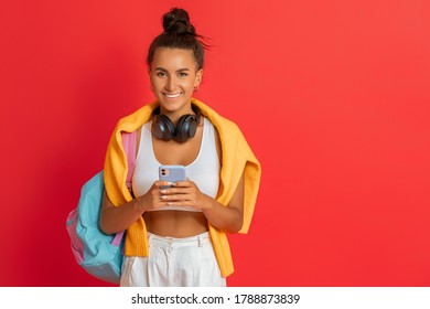 Happy Emotional Young Woman In Sporty Clothes Laughing On Bright Red Background