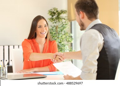 Happy employee and boss handshaking after a successful job interview at office - Powered by Shutterstock