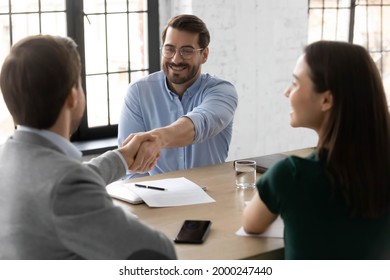 Happy Employee Candidate Shaking Hands With Employer Or Recruiter On Job Interview. Couple Consulting Bank Broker Or Lawyer, Meeting With Real Estate Agent For Consultation, Giving Handshake