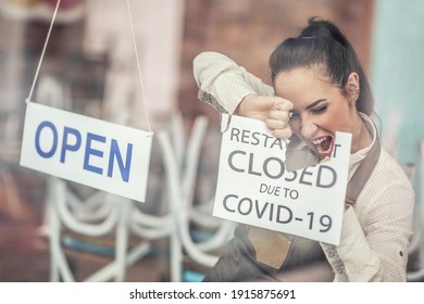 Happy Employee Reopens Restaurant After Covid-19 Tearing A Sign About Closure, Hanging Sign Saying It Is Open Again. 