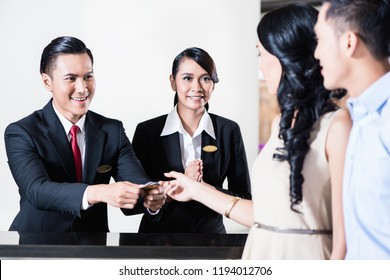 Happy Employees Are Welcoming Young Couple Guest In Hotel