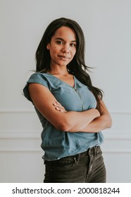 Happy Empowering Black Woman Standing By A White Wall