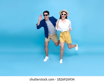 Happy Energetic Asian Couple Tourist Running To Travel On Holidays Isolated On Blue Background.