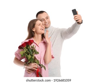 Happy Engaged Couple Taking Selfie On White Background