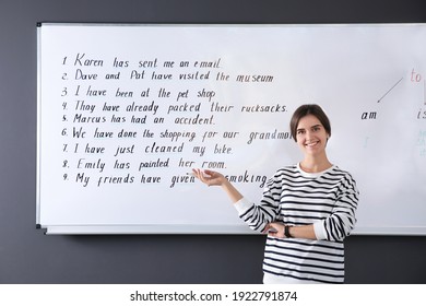 Happy English teacher near whiteboard at lesson - Powered by Shutterstock