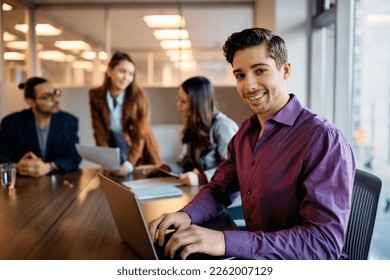 Happy entrepreneur using laptop during business meeting in the office and looking at camera. - Shutterstock ID 2262007129