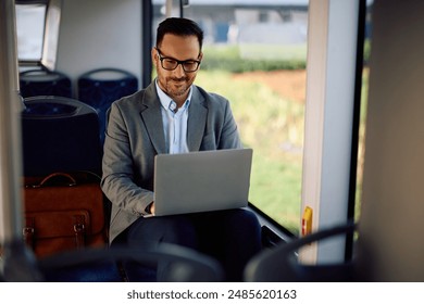 Happy entrepreneur using laptop while riding in a bus. Copy space. - Powered by Shutterstock