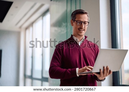 Happy entrepreneur using laptop while working in the office. Copy space.