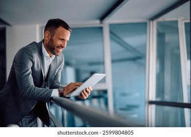 Happy entrepreneur using touchpad while working at corporate office. Copy space. 