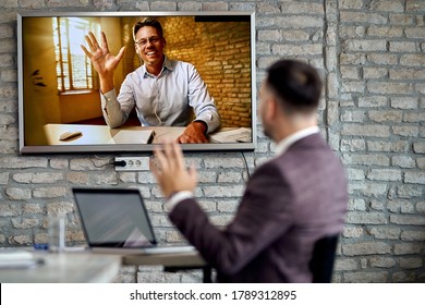 Happy Entrepreneur Waving While Joining A Business Meeting Via Conference Call. 