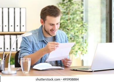 Happy entrepreneur working reading a letter in a desk at office