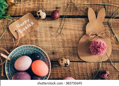 Happy Ester! Top View Of Colored Easter Eggs And Easter Decorations Lying On Wooden Rustic Table