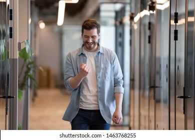 Happy Euphoric Young Business Man Celebrating Professional Victory Win Success With Yes Gesture Walking In Hallway, Satisfied Male Winner Excited By Work Reward Promotion Dancing On Friday In Office