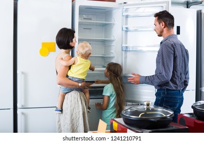 Happy European Family Of Four Shopping New Refrigerator In Home Appliance Store 
