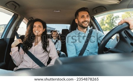 Happy european family of three riding car, traveling by automobile together, parents and daughter enjoying road trip on weekend, panorama
