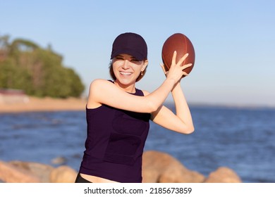 happy european girl playing, winning in american football on beach. young female team player with rugby ball smiling, laughing. prefabricated games, pastime, sports, active recreation for youth - Powered by Shutterstock