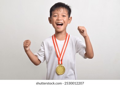 Happy and excited asian boy holding a first place gold medal isolated on a white background. The boy celebrating his victory - Powered by Shutterstock