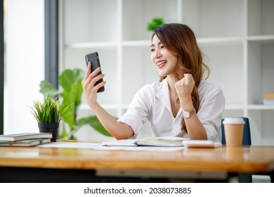 Happy Excited Asian Business Woman In Office Working With Mobile Phone,Yes Great Job.