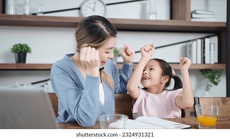 Happy excited asian mother and little daughter raise hands up celebrate success, finishing doing homework at home on weekend. Single mother, Mother and child relationship concept - Powered by Shutterstock