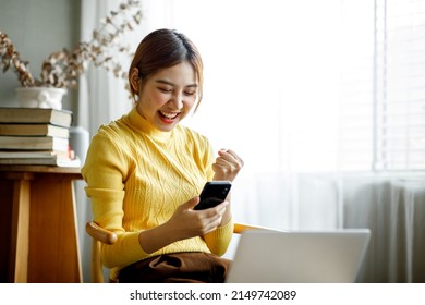 Happy Excited Asian woman looking at the Smartphone screen, celebrating an online win, overjoyed young Asian girl screaming with joy, isolated over a white blur background,