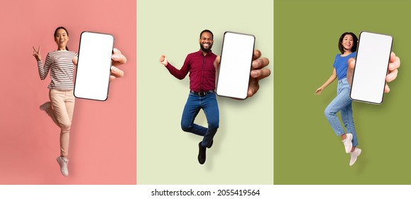 Happy excited asian women and african american man jumping from joy and showing phone with empty screen, isolated on colored background. Virtual advertising, great offer and good website, collage
