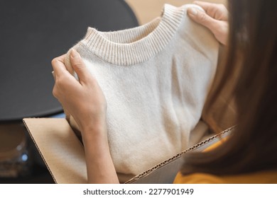 Happy excited, asian young woman, girl customer sitting on sofa at home, open and unpack cardboard box carton parcel after buy fashion clothes, ordering present and shopping online, delivery service. - Powered by Shutterstock