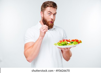 Happy excited bearded man holding plate with fresh sala a,