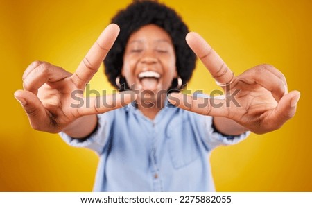 Happy, excited and black woman with a peace sign in studio with positive and goofy mindset. Happiness, smile and African female model with an afro posing with a v hand gesture by yellow background.