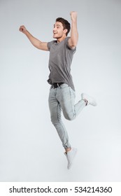 Happy Excited Cheerful Young Man Jumping And Celebrating Success Isolated On A White Background