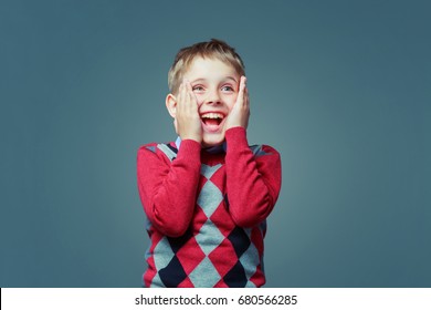 Happy Excited Child Wearing A Sweater  Isolated Against Grey Background