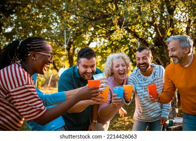 Happy Excited Diverse Group Of People Cheering With Colorful Glasses Outdoor In Backyard Party