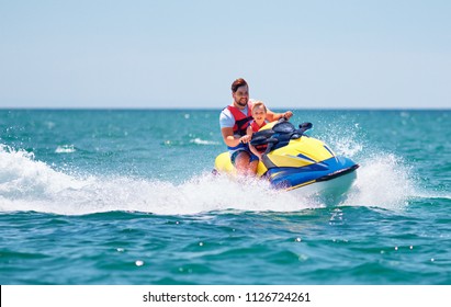 happy, excited family, father and son having fun on jet ski at summer vacation - Powered by Shutterstock