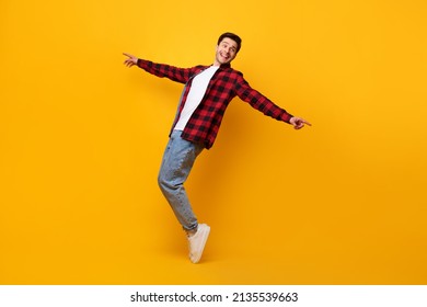 Happy excited funny man dancing to favorite song standing on tiptoes isolated over yellow orange studio background wall, pointing at copy space. Male doing disco moves enjoying sound and music, banner - Shutterstock ID 2135539663