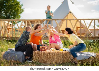 Happy And Excited Group Of Friends Have A Good Time Together In The Middle Of Nature At The Campsite One Of The Guy Came To The Group Of Friends Saying Hi And Sitting Down