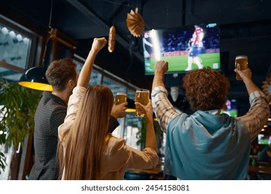 Happy excited group of friends watching football match on tv in pub - Powered by Shutterstock