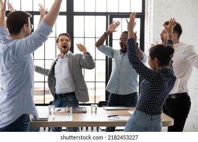 Happy excited millennial employees shouting for joy, raising hands for emotional high fives. Business team of overjoyed professionals cheering, celebrating good sales result, financial goal achieving - Powered by Shutterstock