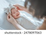 Happy excited newborn baby laughing at mom face, positive emotions, Mother wearing ribbon headband for her daughter, A happy family