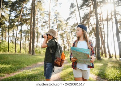 Happy excited school children with backpacks in casual clothes enjoying walk in forest on sunny autumn day, two active kids boy and girl running and playing together during camping trip in nature - Powered by Shutterstock