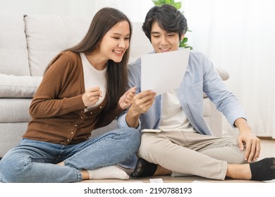 Happy Excited, Smiling Asian Young Couple Love, Wife And Husband Hold Paper Letter, Reading Paperwork Document Getting, Receive Job Promotion, Tax Refund Or Loan Mortgage Approval, Good News By Mail.