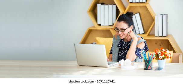 Happy excited successful Beautiful businesswoman triumphing in modern office with laptop, success happy pose. Work from home and social distancing concept