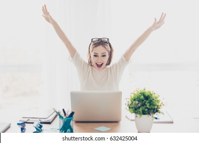 Happy excited successful businesswoman triumphing with laptop