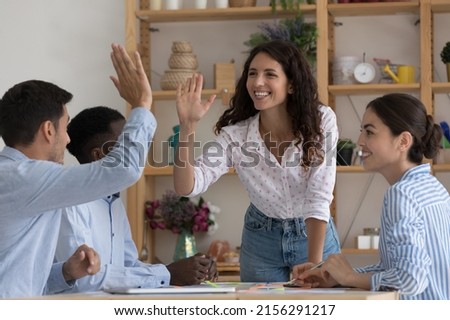 Happy excited two employees giving high five, celebrating team success, work achieve, sales result, thanking for successful idea, completing project, enjoying teamwork together