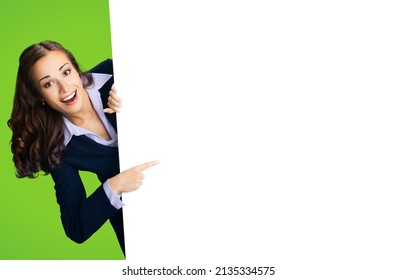 Happy excited woman in black confident suit showing pointing mock up mockup white banner sign bill board. Business advertising concept. Copy space free area place for text. Green color background.	 - Powered by Shutterstock