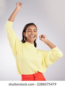 Happy, excited and woman dance, celebration and cheerful against a grey studio background. Female dancer, model and person moving, groove and happiness with routine, motivation and stress relief